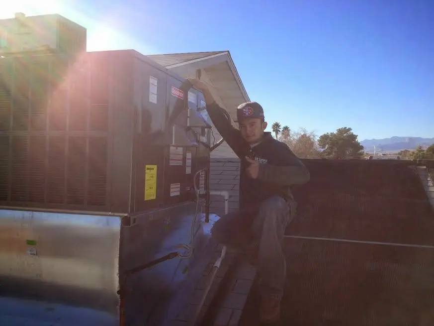 HVAC technician performing AC Tune-Up on a rooftop unit in Highland Springs